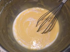 分4-5次将香草牛奶加入蛋黄糊内（取掉香草壳）