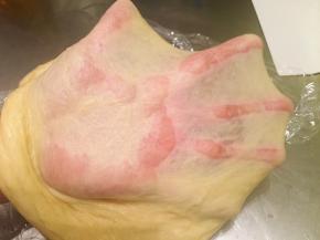 先1档搅拌无干粉后转2档揉成光滑能拉出有弹性的薄膜后放入黄油，揉至薄而不易破的手套膜