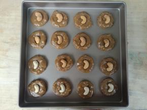 分成16份，用手揉成圆球，按扁，表面装饰一颗腰果。排入烤盘。