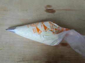 裱花带装入自己喜欢的裱花嘴，把剩余奶油装入裱花袋。