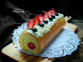 挤在蛋糕卷表面，装饰上草莓，蓝等各色水果。