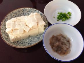 3、豆腐用清水冲洗干净后装盘切小块，虾茸加料酒、盐、蛋清拌匀，葱切成葱花。