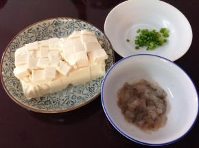 3、豆腐用清水冲洗干净后装盘切小块，虾茸加料酒、盐、蛋清拌匀，葱切成葱花。
