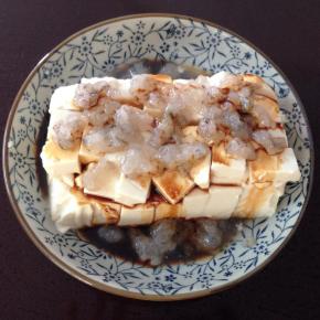 4、把虾茸放在豆腐上，淋上生抽。蒸锅加水煮开后放入豆腐蒸十分钟即可。