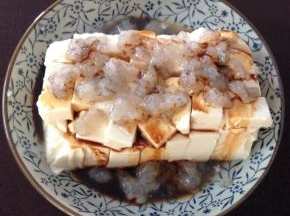 4、把虾茸放在豆腐上，淋上生抽。蒸锅加水煮开后放入豆腐蒸十分钟即可。