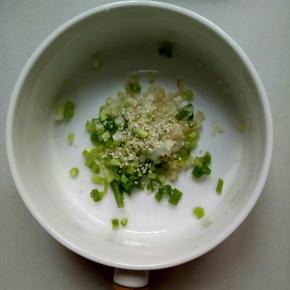 葱切葱花，姜切细丁，熟芝麻少许放入碗里，香菜切碎备用