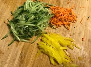 煮面时处理配菜：我用的黄瓜丝和胡萝卜丝，又准备了些小咸菜。