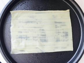 电饼铛预热，加少许植物油。取一张冷面胚子放在电饼铛里。