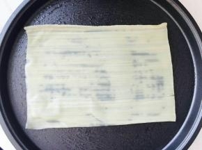 电饼铛预热，加少许植物油。取一张冷面胚子放在电饼铛里。