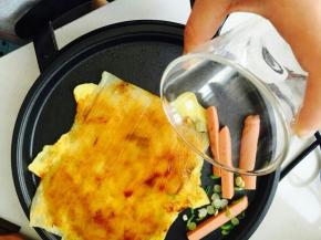 酱料抹匀，火腿和香葱放在一旁煎。喜欢火大的可以跟冷面同时放进去。