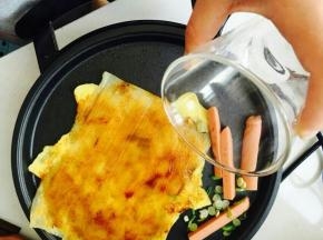 酱料抹匀，火腿和香葱放在一旁煎。喜欢火大的可以跟冷面同时放进去。