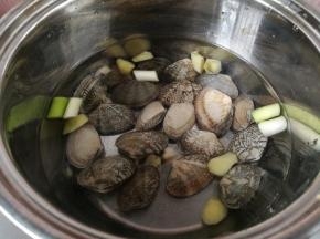 1蛤蜊清洗干净，表面可以用牙刷刷刷，放入锅里，加入葱花，姜片，料酒。