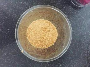 取小杯子，将打碎的消化饼干放在杯底压实。