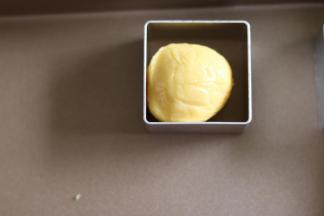 11把包好的凤梨酥，放入凤梨酥模具，按扁，用模具自带的工具压平。