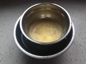 将牛奶蛋黄液倒入容器中,放在刚接的凉水盆中隔水冷却