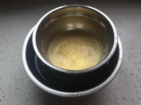将牛奶蛋黄液倒入容器中,放在刚接的凉水盆中隔水冷却