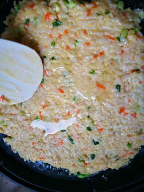 电饼铛加少许油，拌好的米饭摊成一个大饼，厚薄摊匀，表皮加点油，盖好盖子焖一会