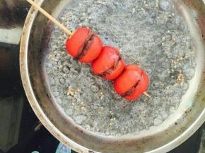 撒上芝麻，均匀的给山楂上糖。