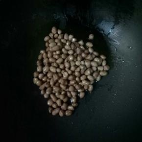 冷锅冷油油要稍多一点，倒入花生米，中小火不停的翻炒