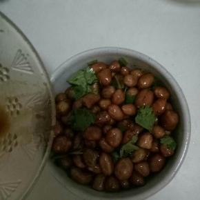 等花生晾凉后，把调料汁倒入花生中，撒上香菜拌匀即可