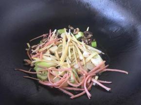 锅里留底油，中火依次爆香八角、葱姜蒜，放入笋丝、火腿丝、香菇丝。