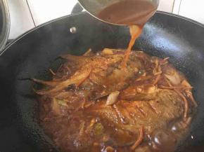 大火煮开后改小火煨炖5分钟，改中火，用大勺舀起汤汁浇在鱼的身上，以便入味，这样的动作要反复几遍，再炖5分钟左右，鱼就熟，把鱼盛在盘子里。