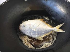 开大火置不粘锅，当锅热时，放约40g左右的油，油5成热时（油面微动），拎住鱼尾沿锅边放进去，刚放进去鱼后千万别用铲子翻动，当煎约2分钟左右时，晃动一下锅，发现鱼可以在锅里滑动时再反面。