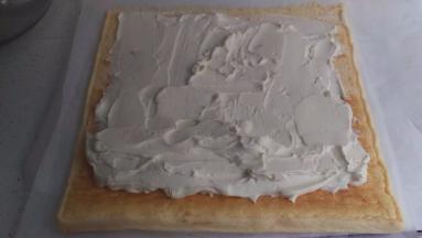 奶油涂在蛋糕的正面，靠近自己的位置涂多点。远的地方涂少点。涂好后就可以开始卷咯，卷好后放冰箱30分钟就可以咯，