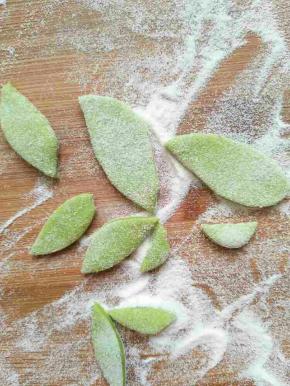 绿色面团擀扁用剪刀剪成两头剪中间宽的树叶形状