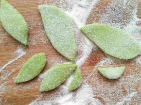 绿色面团擀扁用剪刀剪成两头剪中间宽的树叶形状