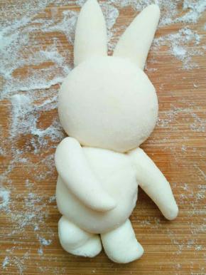 再取两块面团搓成较短粗的长条，做兔子腿，继续抹水固定好，小兔子造型完成