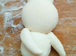 再取两块面团搓成较短粗的长条，做兔子腿，继续抹水固定好，小兔子造型完成