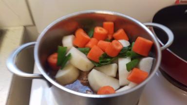 中间1个小时的时候加入白萝卜和红萝卜还有葱断。再继续炖。