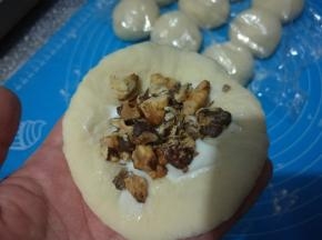 擀开成圆形，包入适量沙拉酱，再放入适量烤熟的核桃仁。