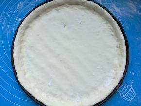 烤箱上下火200度预热10分钟。面团取出，擀成圆片，放进刷了油的披萨盘内，用手推整出圆边。