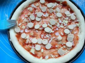 刷上披萨酱，撒上切好的小香肠。