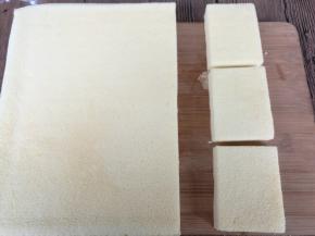 用一张干净的油纸盖在蛋糕表面，翻过来，揭去油布。蛋糕切合适的小块。