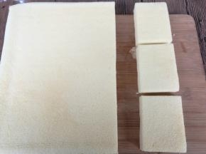 用一张干净的油纸盖在蛋糕表面，翻过来，揭去油布。蛋糕切合适的小块。