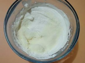 2、加入过筛的玉米淀粉和奶粉，用切拌的手法拌匀。