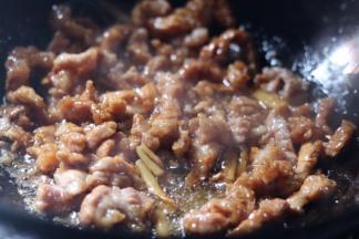 7.放入一小勺料酒，一勺生抽翻炒均匀
