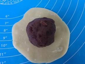 擀成圆片，包入红豆馅球。