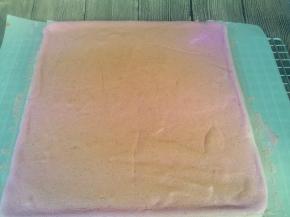 再用揭开的油布盖在蛋糕卷上，翻过来，拿开油纸。