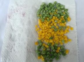 玉米粒和青豆用水焯熟，厨房纸巾抹干水分，。加入盐稍拌一下