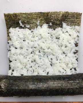 再准备一张海苔，铺一层白色米饭，卷在寿司最外测，接口用沙拉酱粘合。