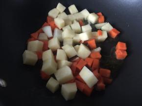 咖喱倒入适量油炒切块的土豆和胡萝卜