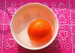 碗里装凉开水，放入少许小苏打粉搅匀，撒上少许盐在橙子上，用力抹，务必要将表皮的蜡洗去，然后放水中静置一会儿，再冲干净