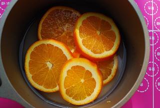放入五片橙片，小火熬煮，7-8分钟后关火，至汁液粘稠，果肉软糯入味，一旁冷却备用