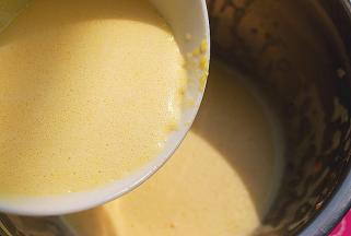 取1/4蛋液倒入融化的黄油和淡奶油液体中，拌匀，再将此液体全部倒入剩余的3/4蛋液中，刮刀拌匀