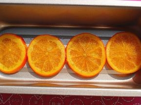 从之前准备好的橙片糖浆中取出4片大小合适的橙片，放入模具中