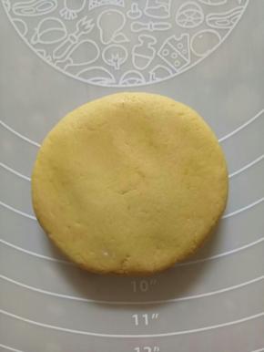 拿一个面团包入豆沙馅儿，搓圆，然后用手指压扁